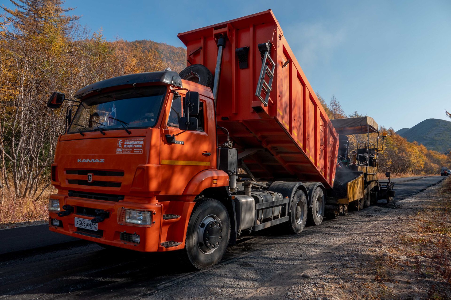 Самосвал с поднятым кузовом на строительном объекте